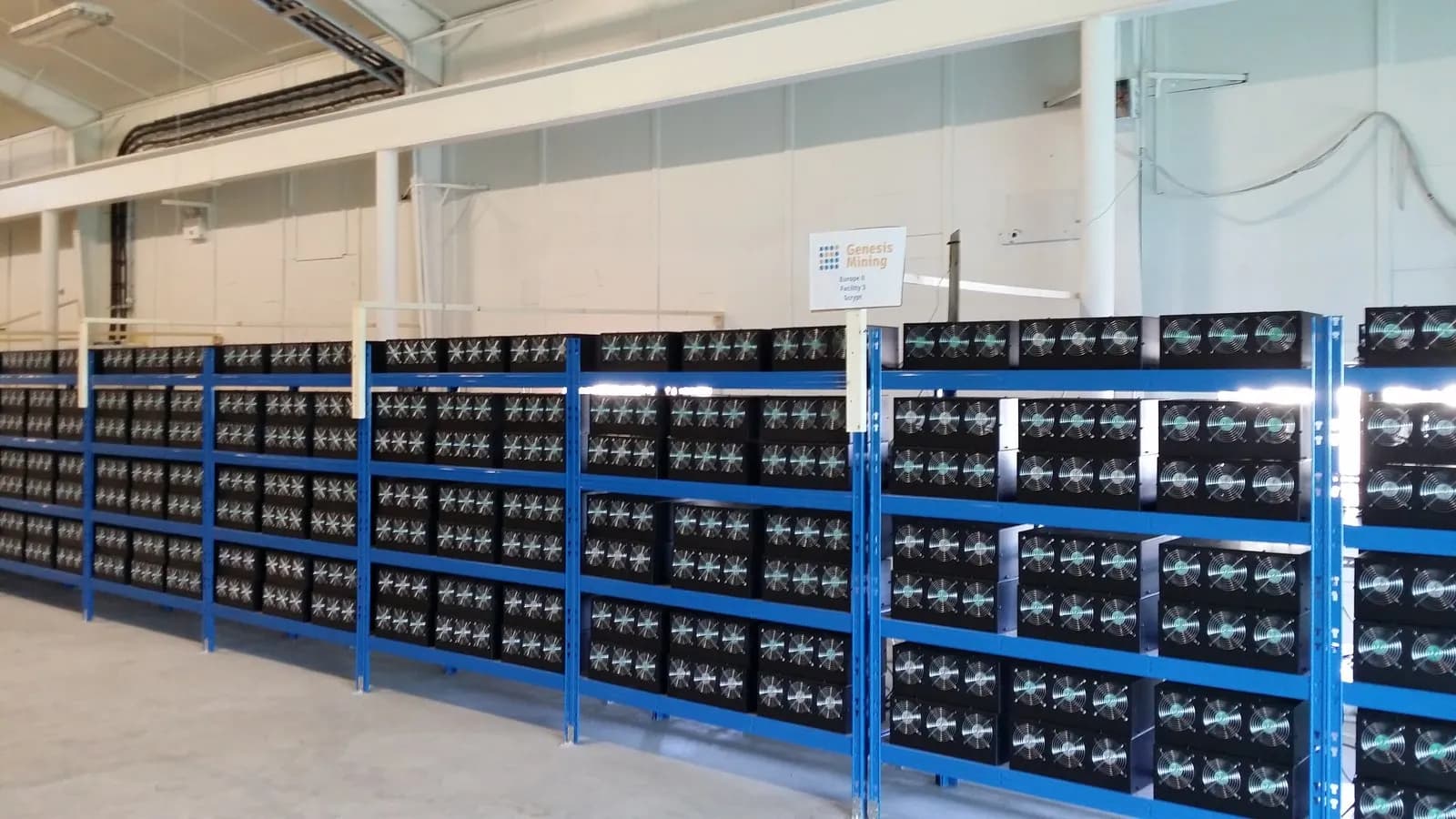 Rows of bitcoin mining machines racked in a cryptocurrency mining facility