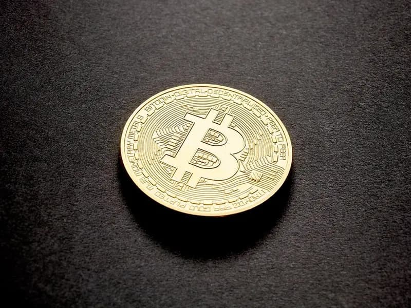 A single gold-coloured physical bitcoin coin lying on a dark surface, photographed on 14 February 2018, a stock illustration of bitcoin and not of Thursday's price move