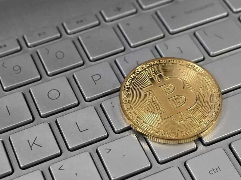 A gold-coloured physical bitcoin coin lying on a white laptop keyboard, photographed in February 2023, a file photograph illustrative of bitcoin and not of this week's price moves