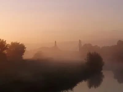 Mist over a river at first light, the sun still low enough to be diffused by the fog