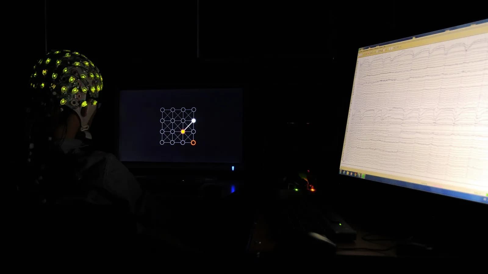 A brain-computer interface experiment, with a participant wearing an electrode cap in front of a screen; the UCSF study used electrodes implanted on the brain's surface