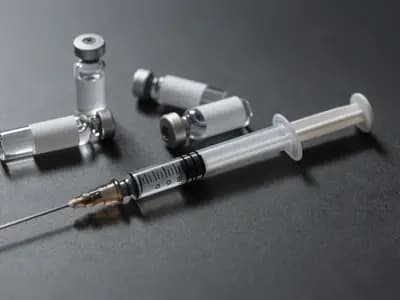 Small unlabelled vials and an insulin syringe on a plain surface