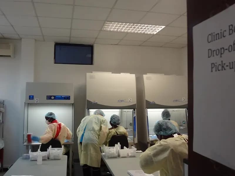 Pharmacists in protective gear prepare doses of an Ebola vaccine during the PREVAIL trial in Liberia in 2016