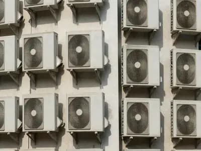 Air conditioning condenser units mounted on the side of an apartment building