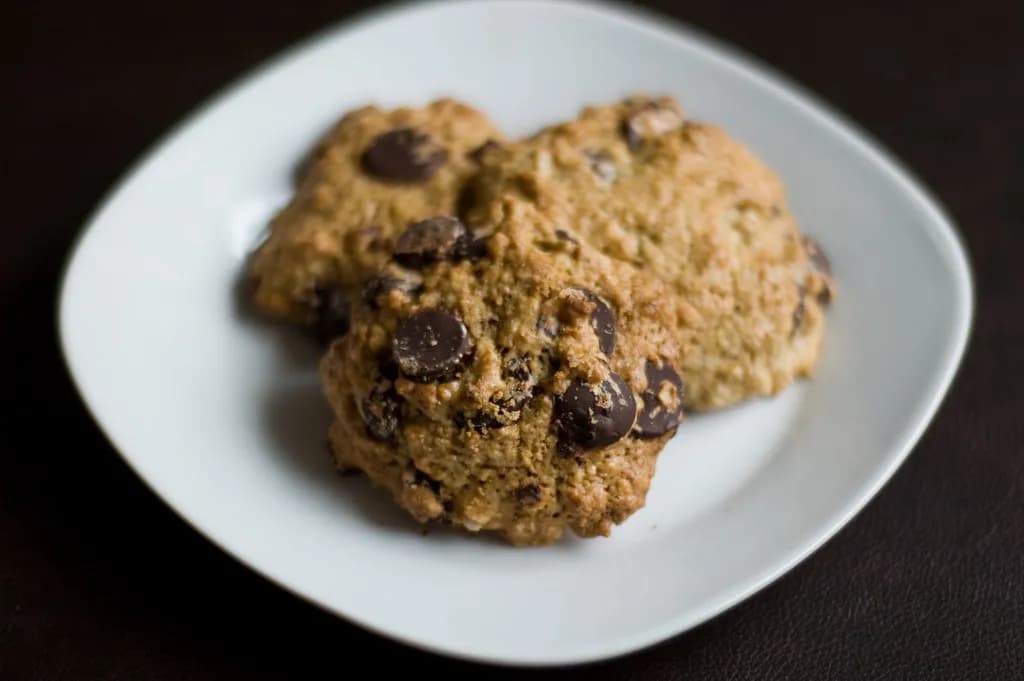 A croissant split open to reveal gooey baked chocolate chip cookie dough packed inside its flaky layers