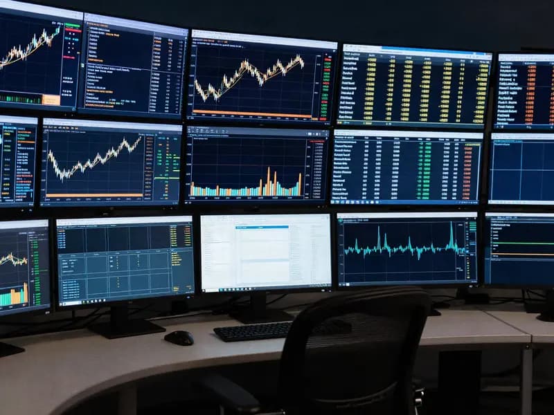 A trading desk at night with multiple chart monitors