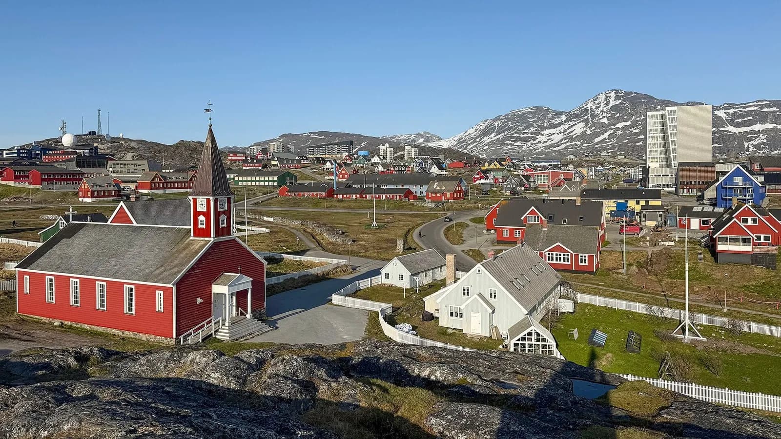A view of Nuuk, the capital of Greenland, with its red wooden cathedral and the hills behind, photographed in June 2025, a file photograph of the town and not of any exploration site