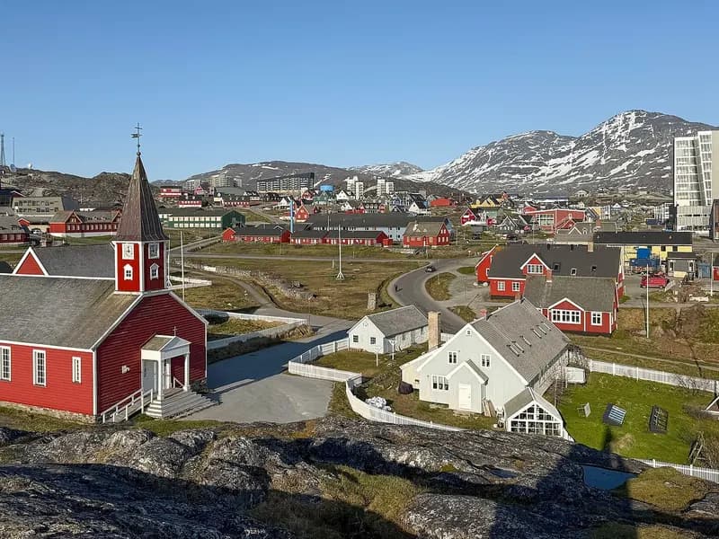 A view of Nuuk, the capital of Greenland, with its red wooden cathedral and the hills behind, photographed in June 2025, a file photograph of the town and not of any exploration site