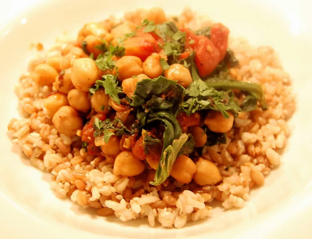 A divided dinner plate with half filled with colourful non-starchy vegetables, a quarter with lean protein, and a quarter with whole grains
