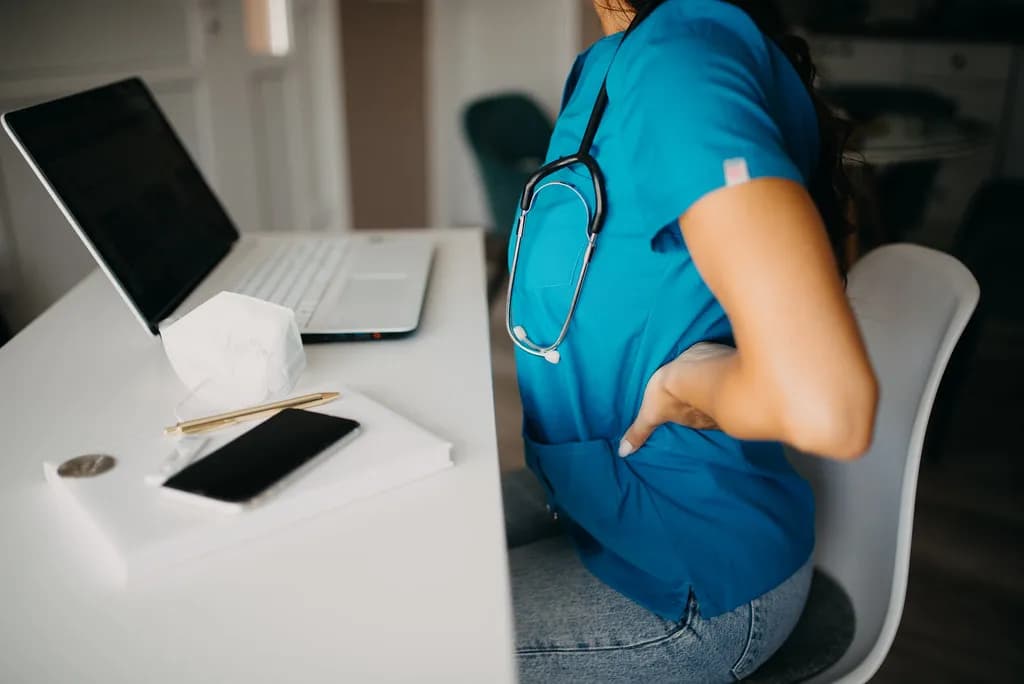 An office worker pausing beside a laptop and silenced smartphone