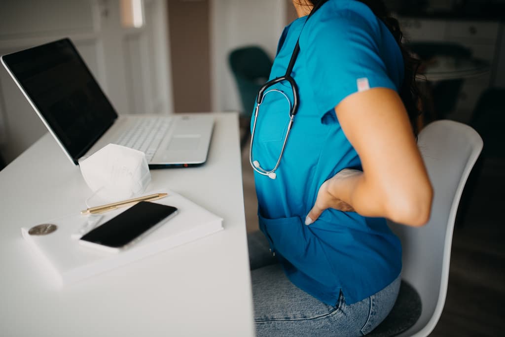 An office worker pausing beside a laptop and silenced smartphone