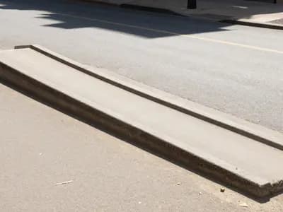 A wheelchair ramp on a city street in summer heat
