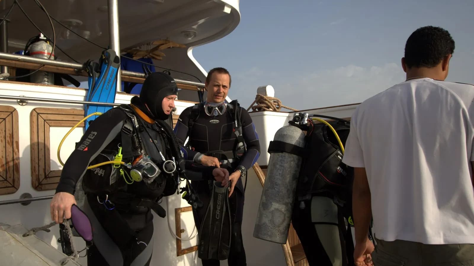 Scuba divers in wetsuits and kit preparing for a morning dive from a boat in Egypt, photographed in April 2008