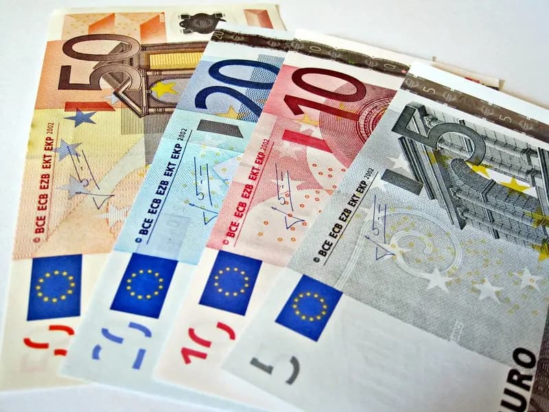 Dollar and euro currencies beside foreign-exchange market charts