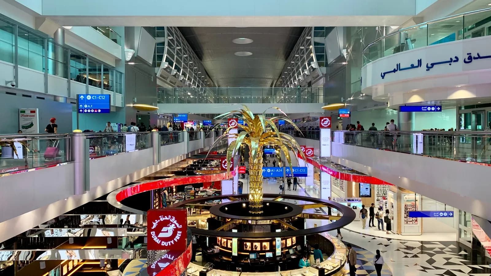 The interior of Terminal 3 at Dubai International Airport, with travellers under its curved roof, photographed in 2019