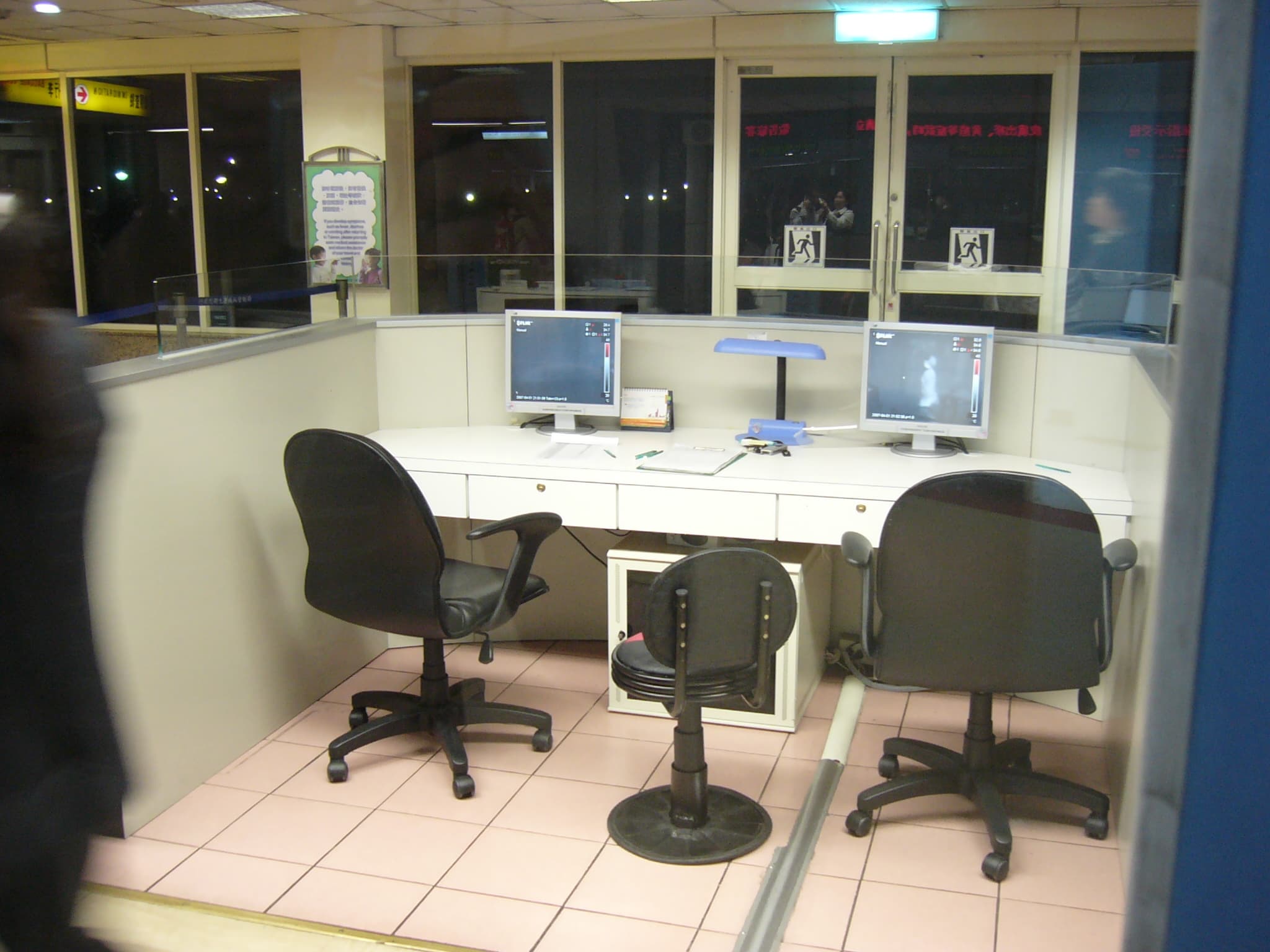 Travelers passing a public-health information point at an international airport