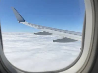 An aircraft wing above cloud, seen from a passenger window