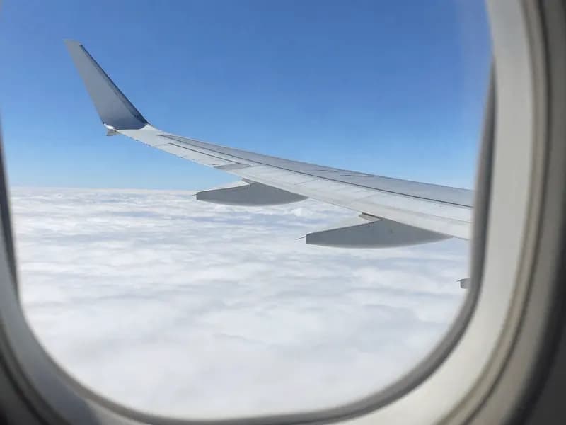 An aircraft wing above cloud, seen from a passenger window