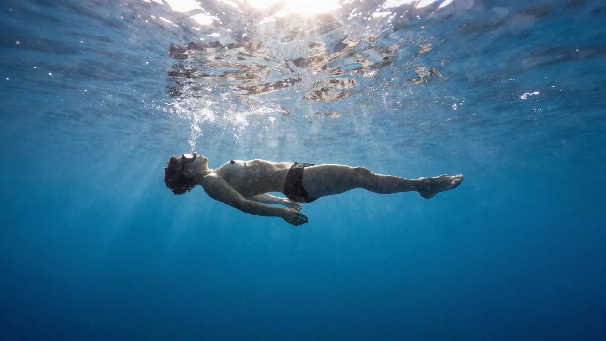 A freediver floating face down and relaxed at the surface