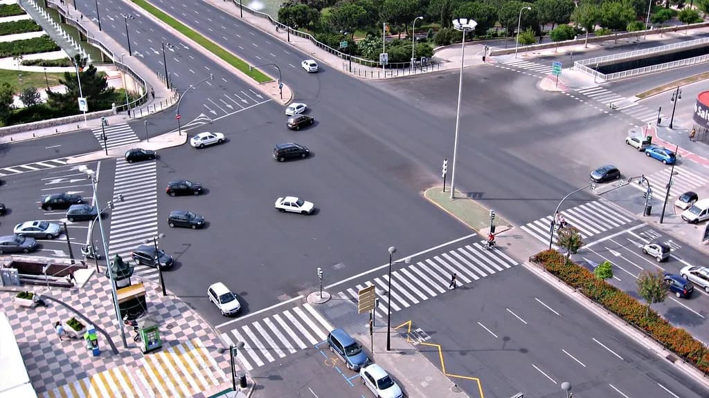 Pedestrians crossing a busy city road at a marked intersection