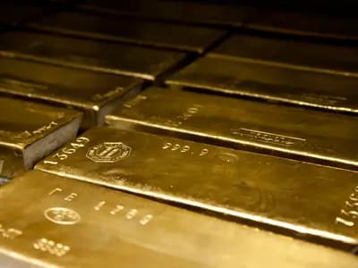 Gold bars beside a professional market chart showing a volatile second-half outlook