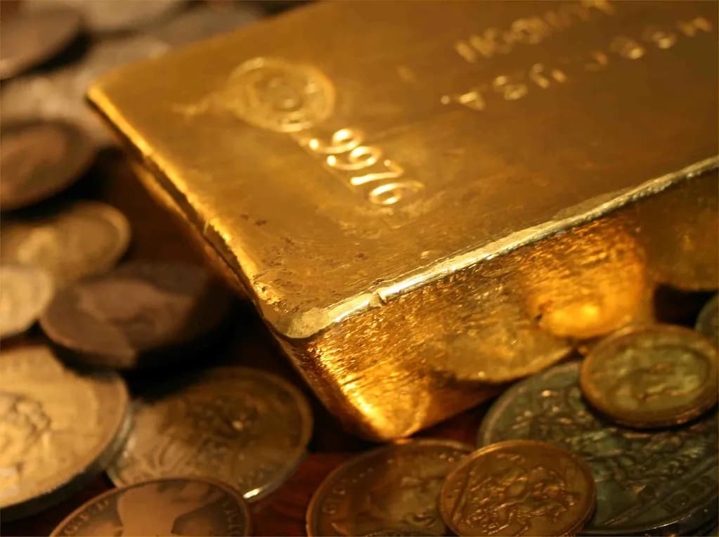 Gold bullion beside market charts in a professional trading setting