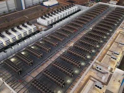An aerial view of rows of rooftop cooling units on a large data centre at night-time lighting, photographed on 23 November 2025, a file photograph illustrative of data centres and not of Google's London zone
