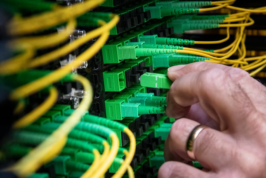 A technician walking between illuminated server racks in a large cloud data center