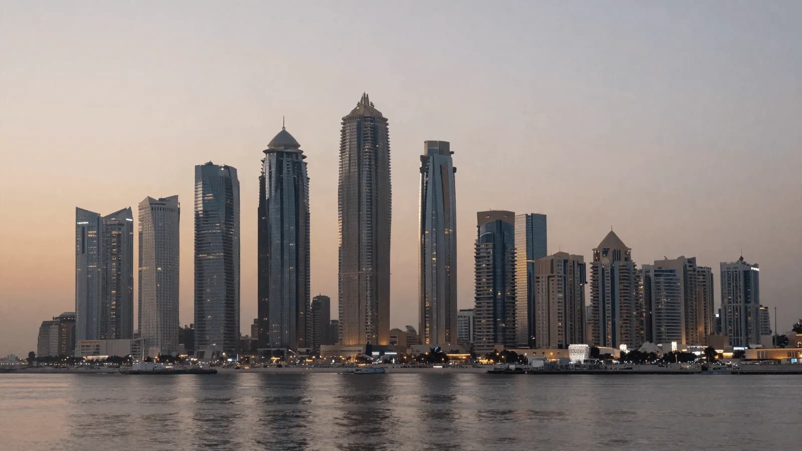Gulf high-rise towers at dusk seen across open water