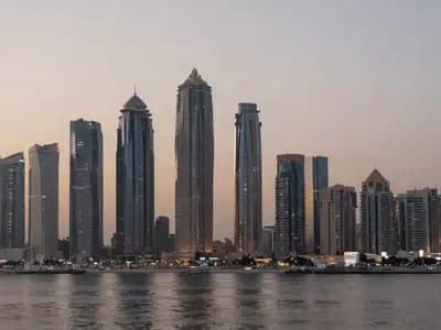 Gulf high-rise towers at dusk seen across open water