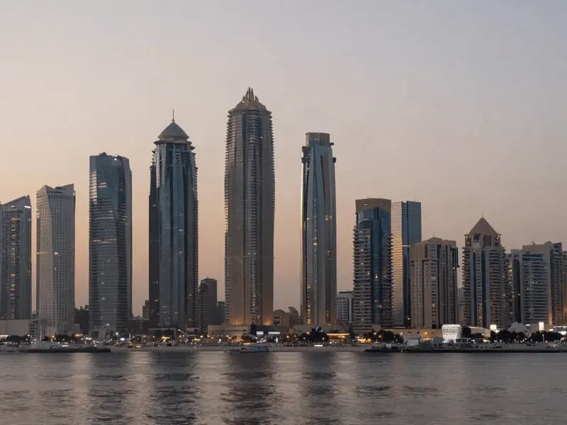 Gulf high-rise towers at dusk seen across open water