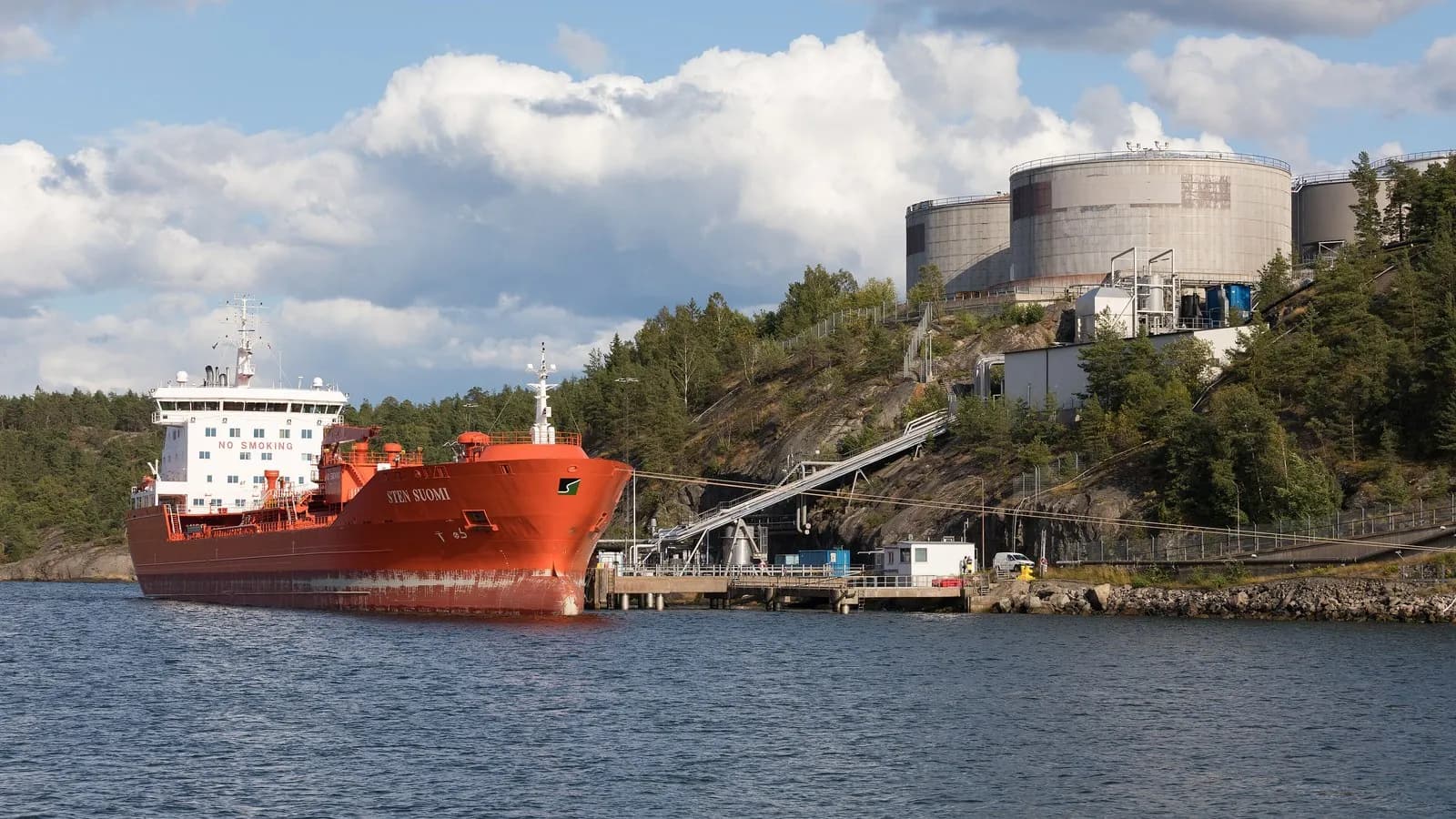 The tanker Sten Suomi berthed at a fuel depot outside Stockholm, with storage tanks on the hillside behind. The vessel struck this week was crossing the Strait of Hormuz