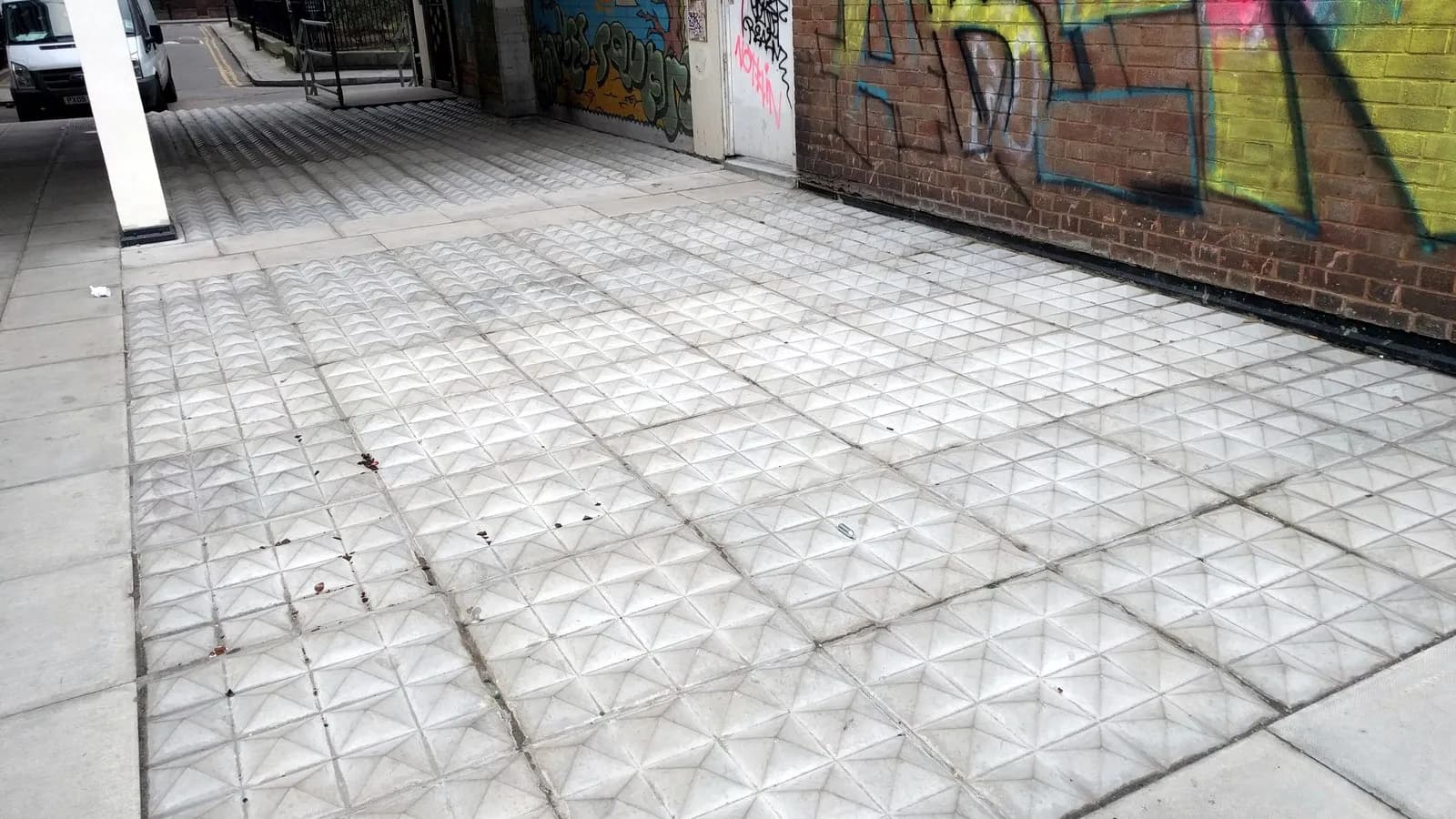 Metal studs set into the ground in a doorway in Shoreditch, London, installed to stop people sleeping there