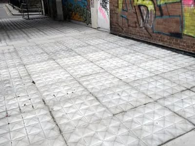 Metal studs set into the ground in a doorway in Shoreditch, London, installed to stop people sleeping there
