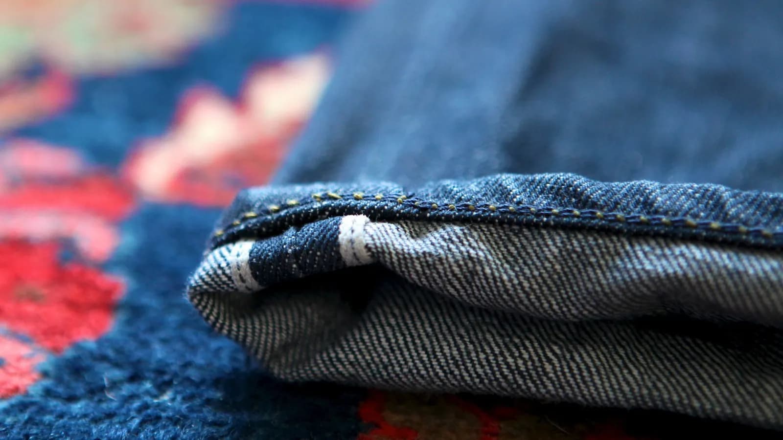 The turned-up cuff of a pair of Tellason selvedge jeans showing the red-line self-finished edge, photographed in 2011