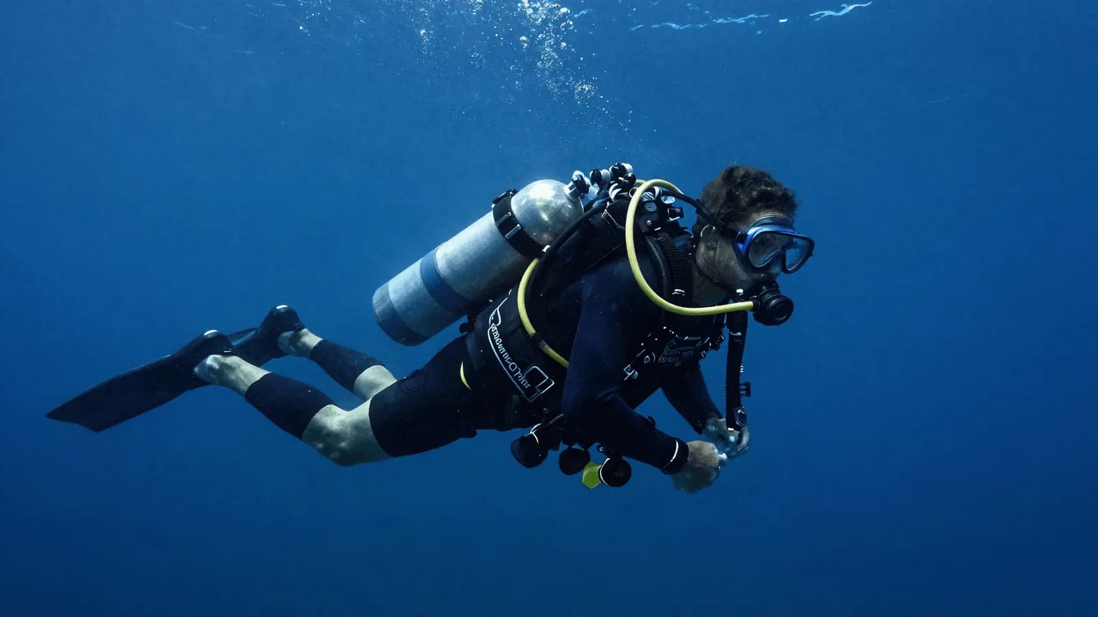 A technical diver in the water carrying stage cylinders during a decompression stop