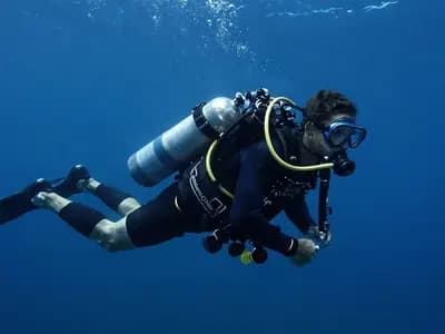A technical diver in the water carrying stage cylinders during a decompression stop