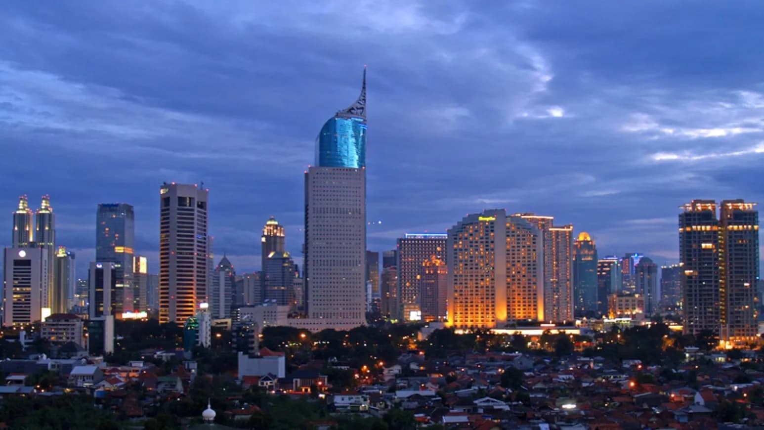 The skyline of Jakarta's central business district at dusk, with office towers lit against a blue evening sky, photographed on 2 March 2008, a file photograph illustrative of Indonesia's capital and not of Friday's trading