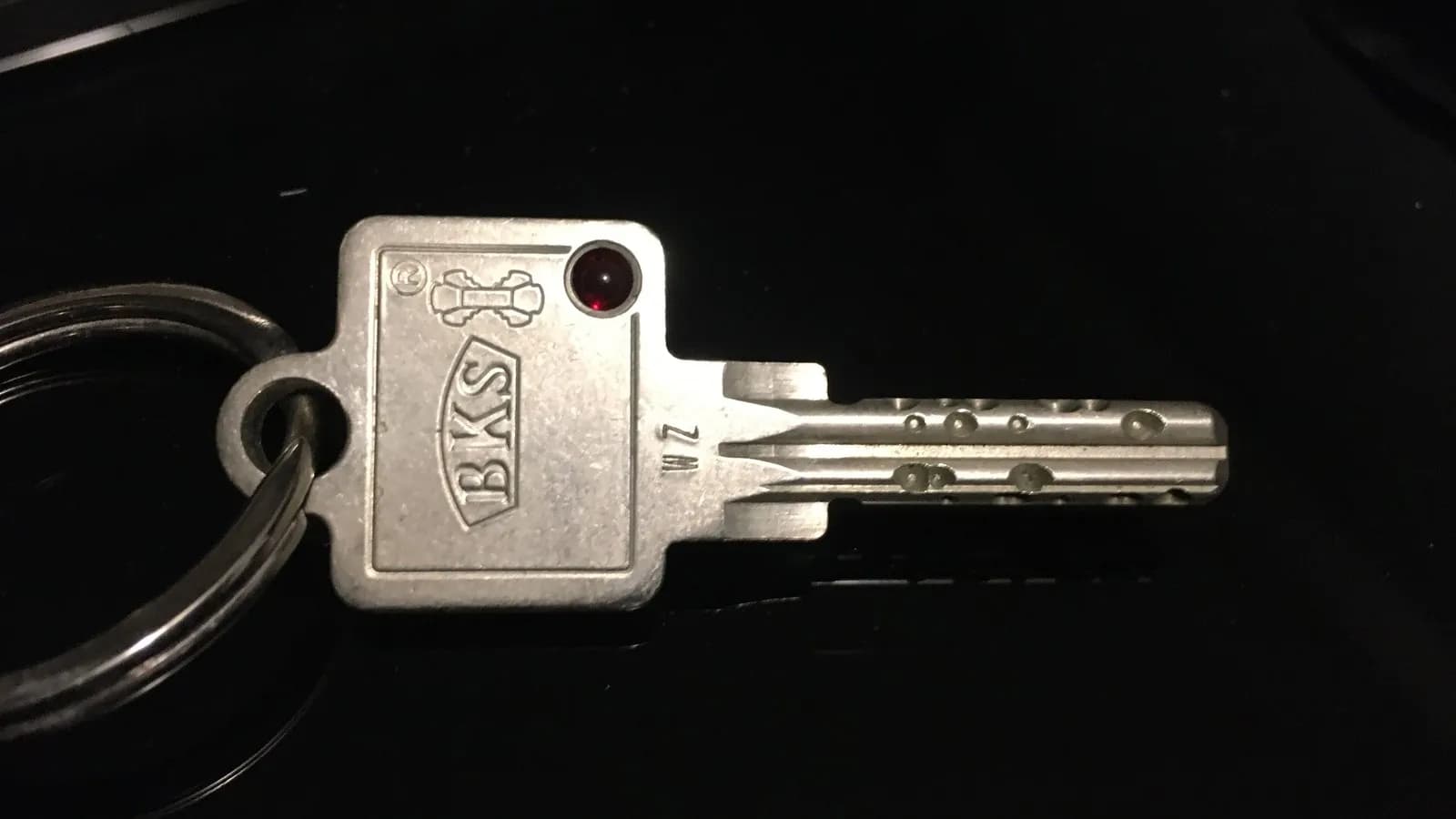 A single door key on a ring, photographed against black. A stolen session token works the same way, as a key already cut that opens the door without anyone being asked who is holding it
