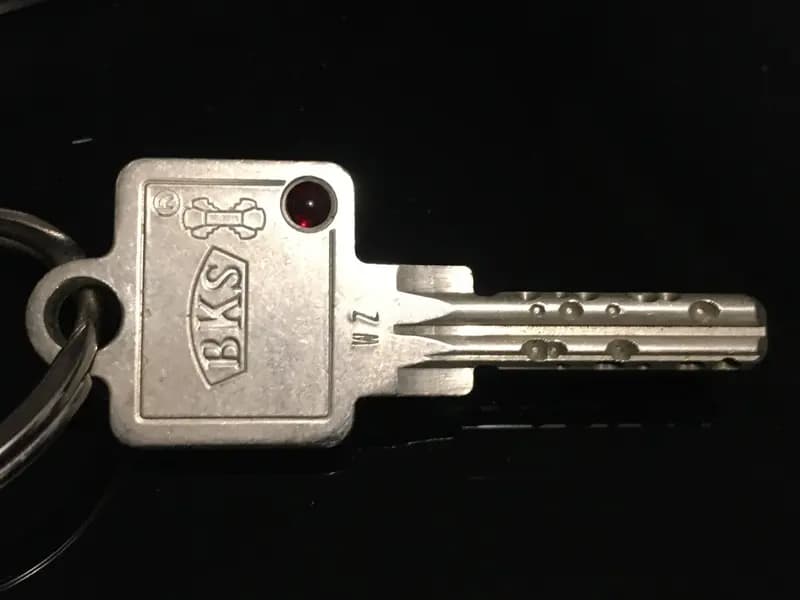 A single door key on a ring, photographed against black. A stolen session token works the same way, as a key already cut that opens the door without anyone being asked who is holding it