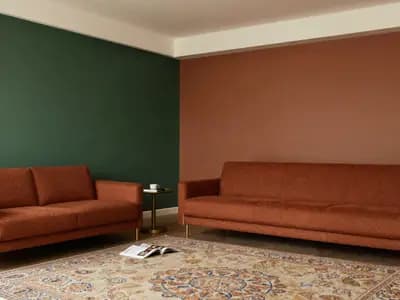 A living room in deep green and terracotta tones