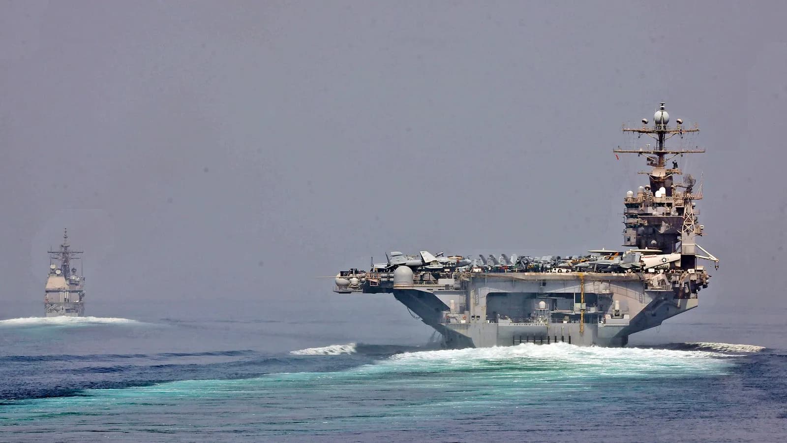 A United States aircraft carrier and an escort transiting the Strait of Hormuz, in an official US Navy photograph