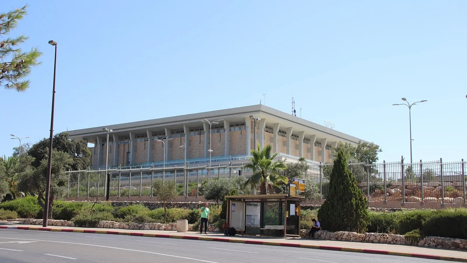 The long, pale-stoned Knesset building in Jerusalem behind a fence and a road under a bright blue sky, photographed on 5 July 2018, a file photograph of the parliament building and not of this week's count
