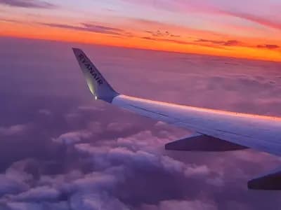 Sunrise over the wing of an airliner at cruising altitude, photographed from a window seat in 2019