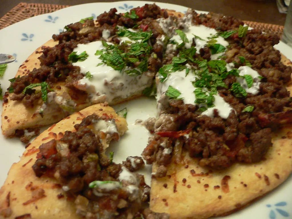 A tray of golden baked kibbeh bil sanieh cut into diamonds with crispy edges
