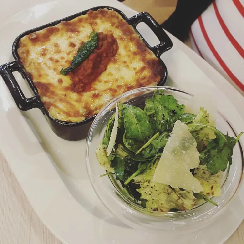 Baked lasagna al forno with golden top showing layers of pasta, ragù, and béchamel