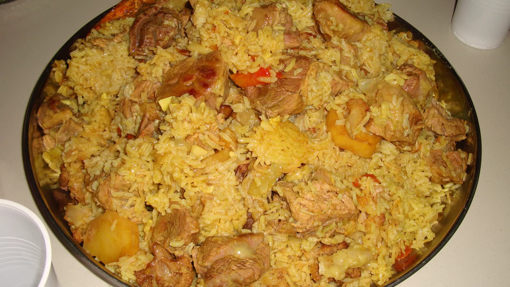 A moulded dome of spiced rice topped with aubergine and toasted nuts on a platter