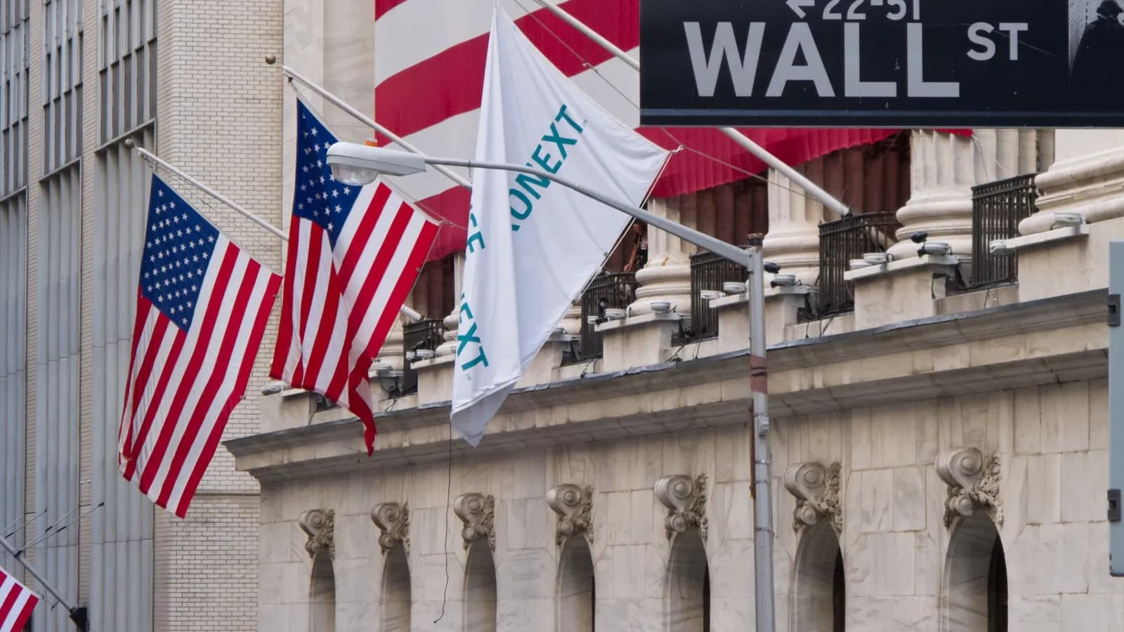 The New York Stock Exchange on Wall Street with flags across its facade, photographed in July 2012