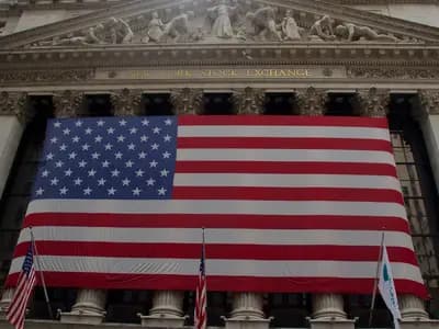 The New York Stock Exchange facade on Wall Street with a large American flag, photographed in July 2012