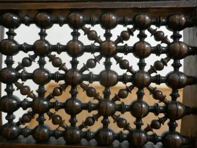 A turned wood mashrabiya screen with carved surround